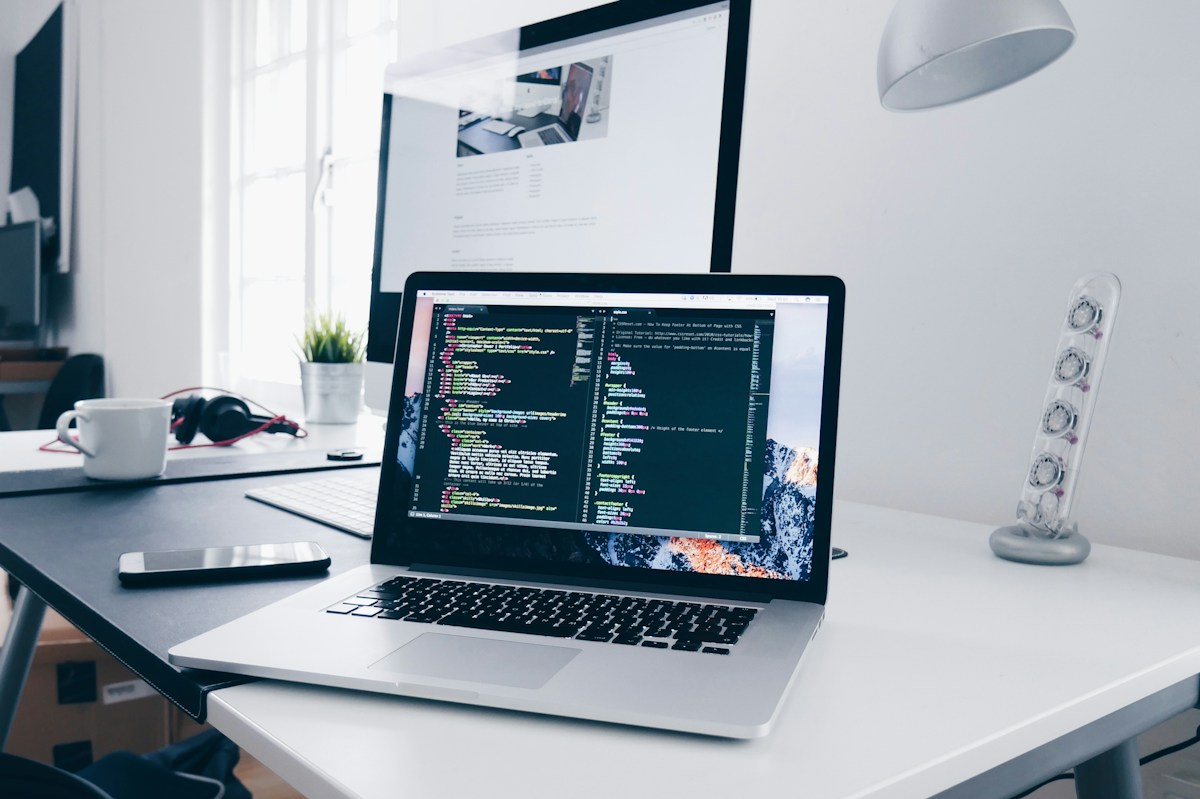 Laptop and monitor in a bright software development workspace